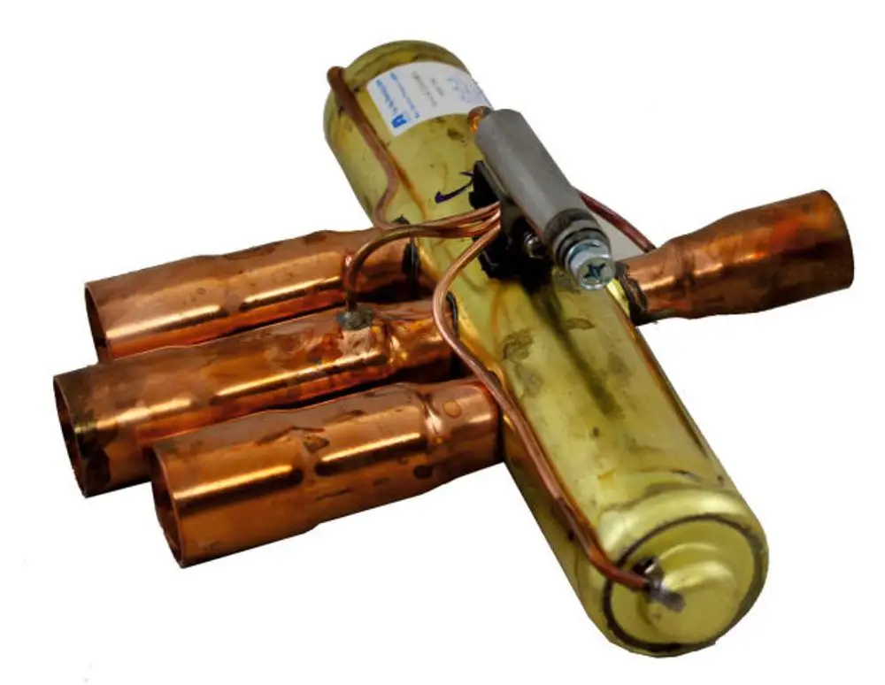 Vierwegeumschaltventil mit mehreren Kupferleitungen und einem zentralen Element, hergestellt von Wolf, geeignet für Heiz- und Kühlsysteme.